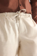 Beige linen drawstring shorts shown in a styled fit, by SOLA Pakistan.