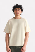 Beige (sand) drop shoulder cotton t-shirt, worn by a model, by SOLA Pakistan.