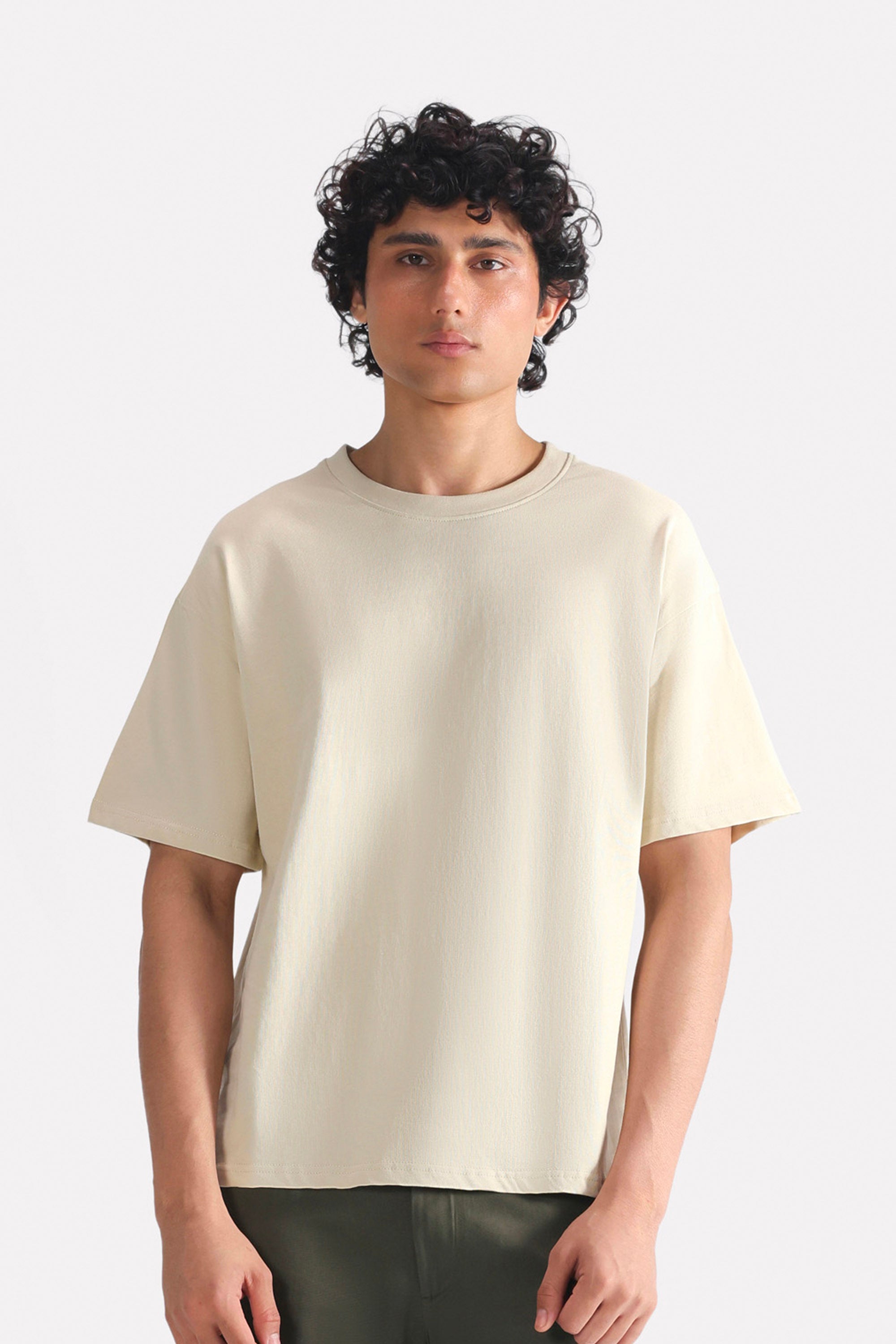 Beige (sand) drop shoulder cotton t-shirt, worn by a model, by SOLA Pakistan.