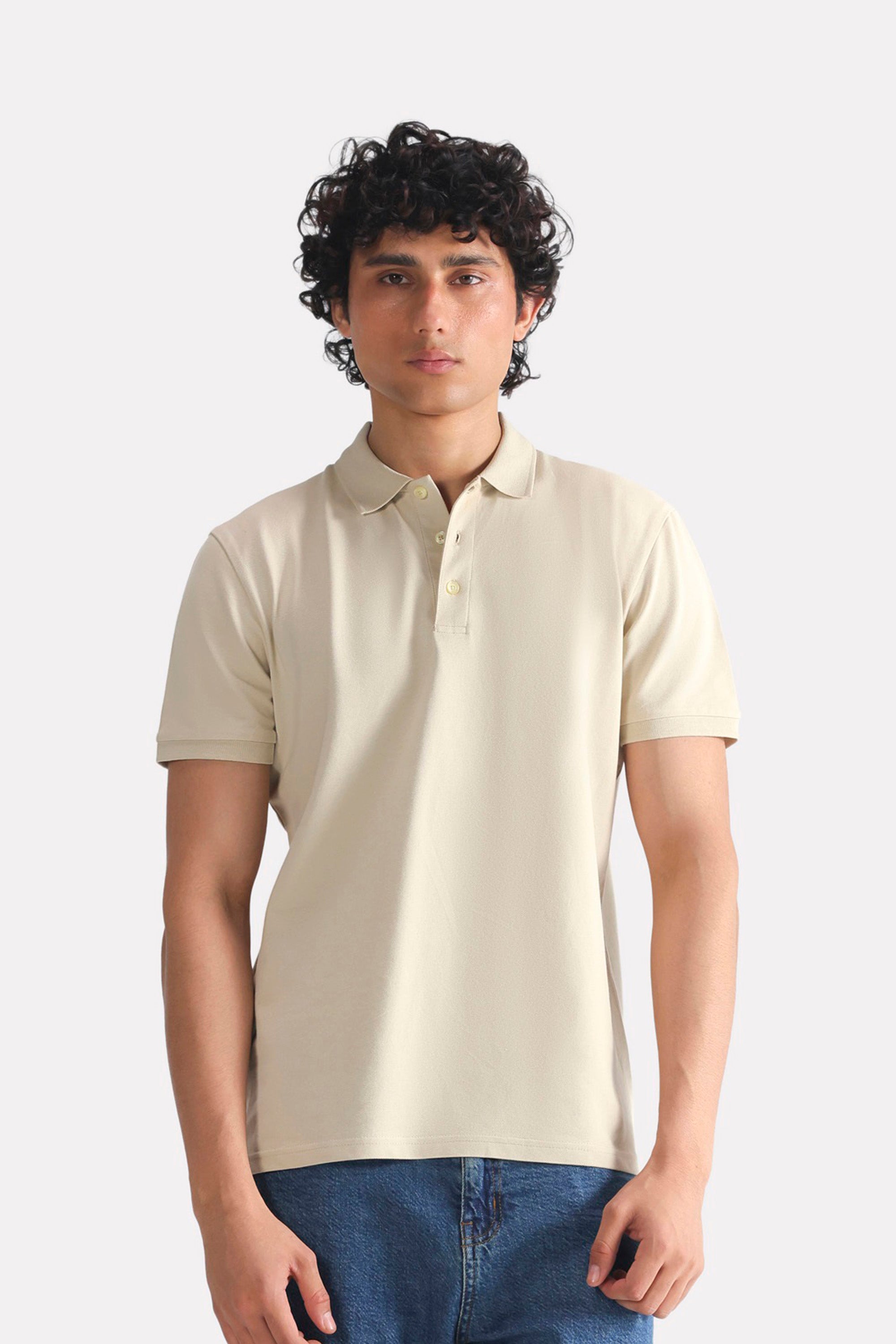 Beige (sand) micro-textured cotton pique polo, worn by a model, by SOLA Pakistan.
