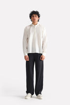 Black barrel-leg pleated trouser in cotton, worn by a model, by SOLA Pakistan.
