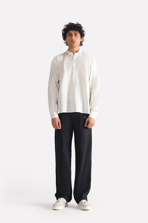 Black barrel-leg pleated trouser in cotton, worn by a model, by SOLA Pakistan.