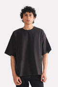 Black drop shoulder cotton t-shirt, worn by a model, by SOLA Pakistan.
