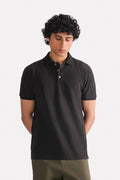 Black micro-textured cotton pique polo, worn by a model, by SOLA Pakistan.