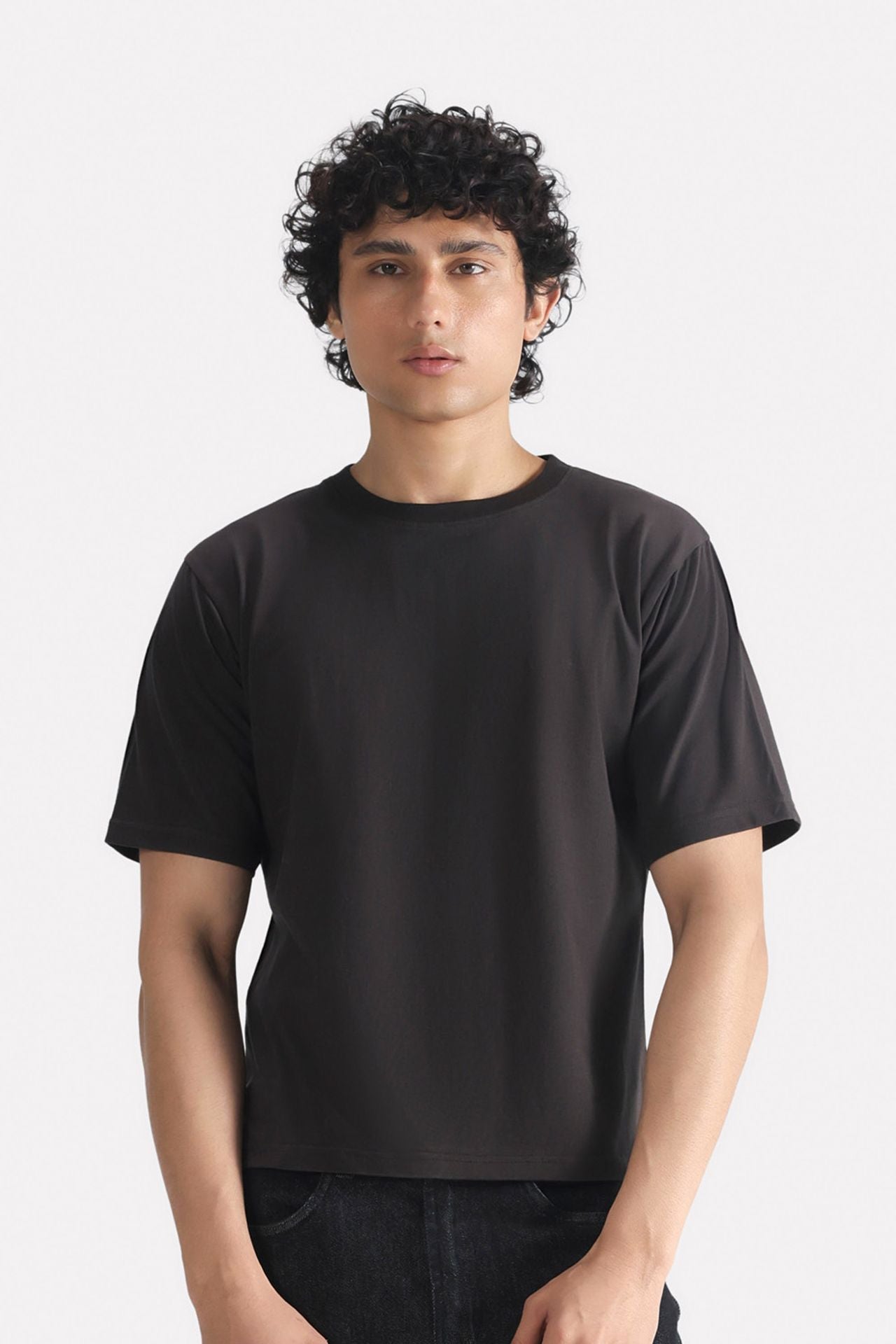 Black regular fit crew neck t-shirt in cotton, worn by a model, by SOLA Pakistan.