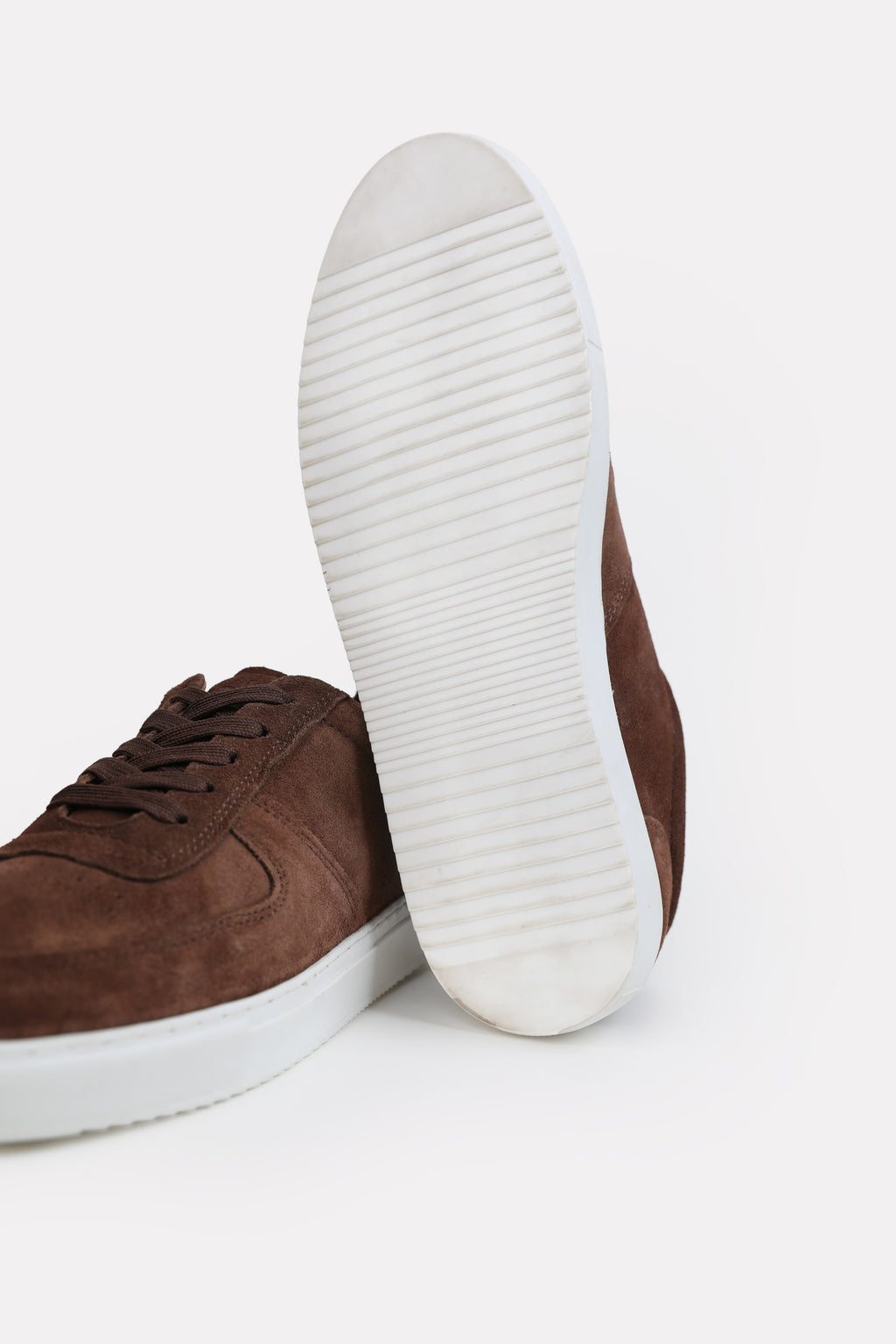 Close-up detail on the brown essence suede trainer, by SOLA Pakistan.
