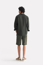 Flat lay of the dark green (charcoal green) state flow button down shirt, by SOLA Pakistan.
