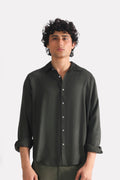 Dark green (charcoal green) state flow button down shirt in linen, worn by a model, by SOLA Pakistan.