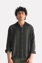 Dark green (charcoal green) state flow button down shirt in linen, worn by a model, by SOLA Pakistan.