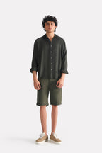 Dark green (charcoal green) state flow button down shirt shown in a styled fit, by SOLA Pakistan.