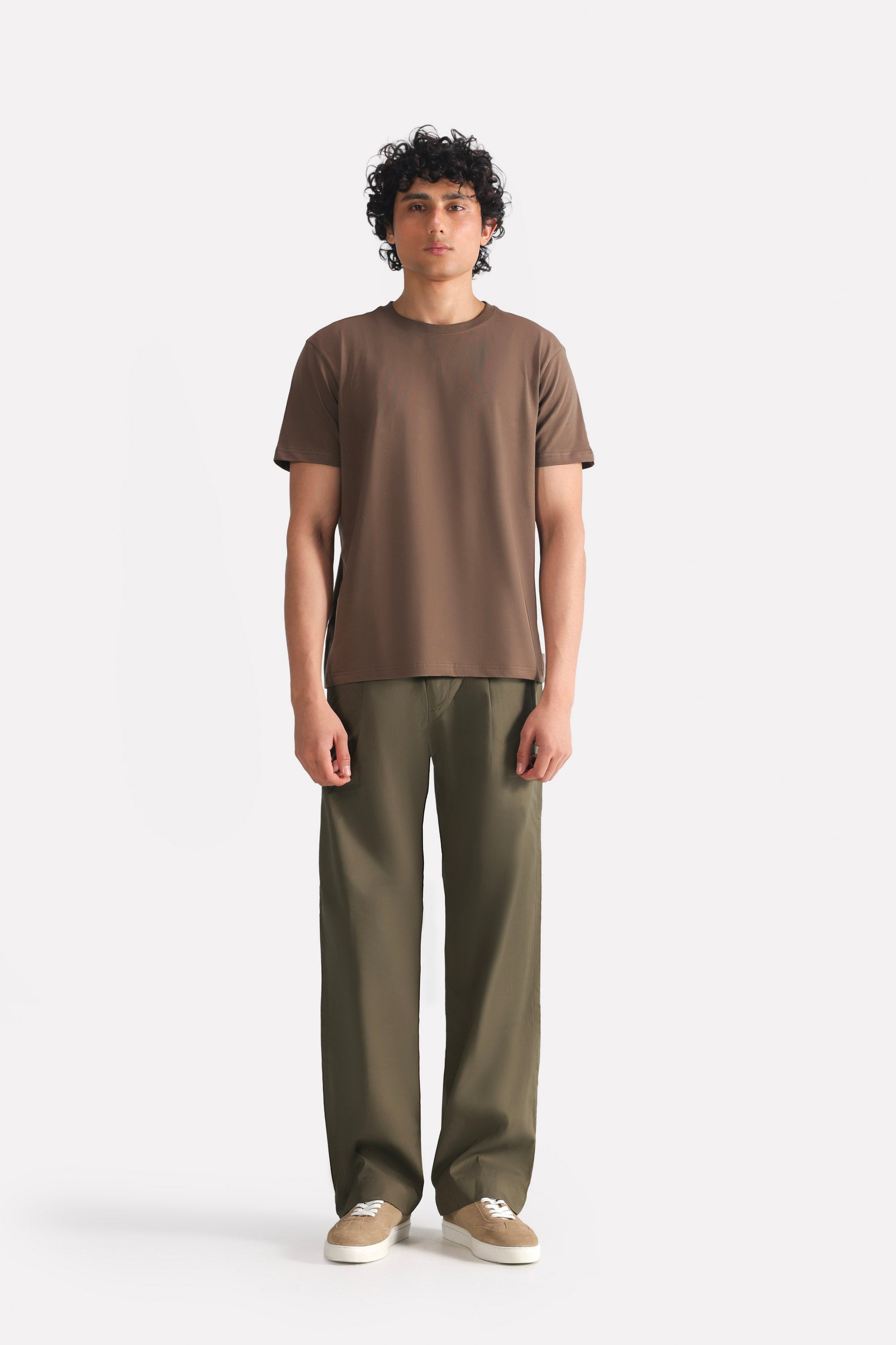 Dark olive barrel-leg pleated trouser in cotton, worn by a model, by SOLA Pakistan.