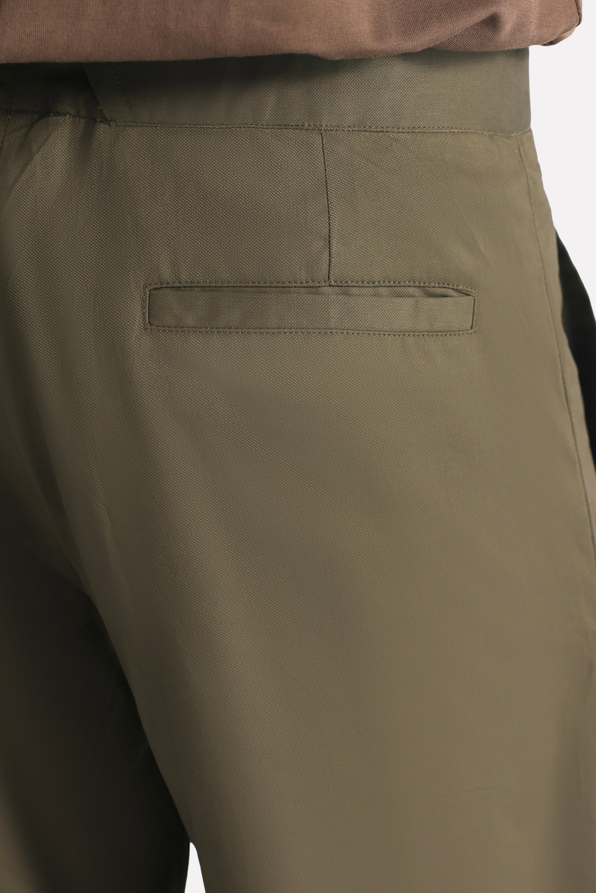 Dark olive barrel-leg pleated trouser shown in a styled fit, by SOLA Pakistan.