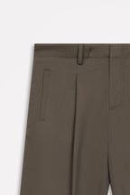 Texture and fabric detail, dark olive barrel-leg pleated trouser, by SOLA Pakistan.