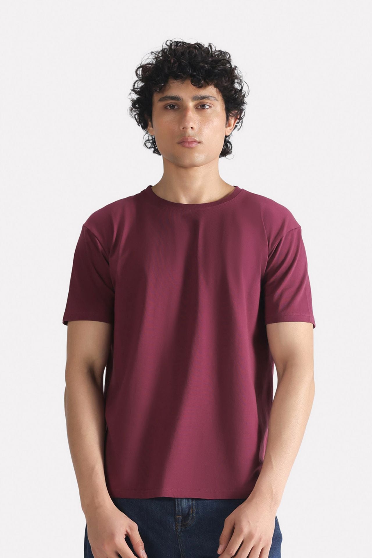 Dark red (burgundy) regular fit crew neck t-shirt in cotton, worn by a model, by SOLA Pakistan.