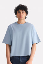 Faded blue (faded denim) drop shoulder cotton t-shirt, worn by a model, by SOLA Pakistan.