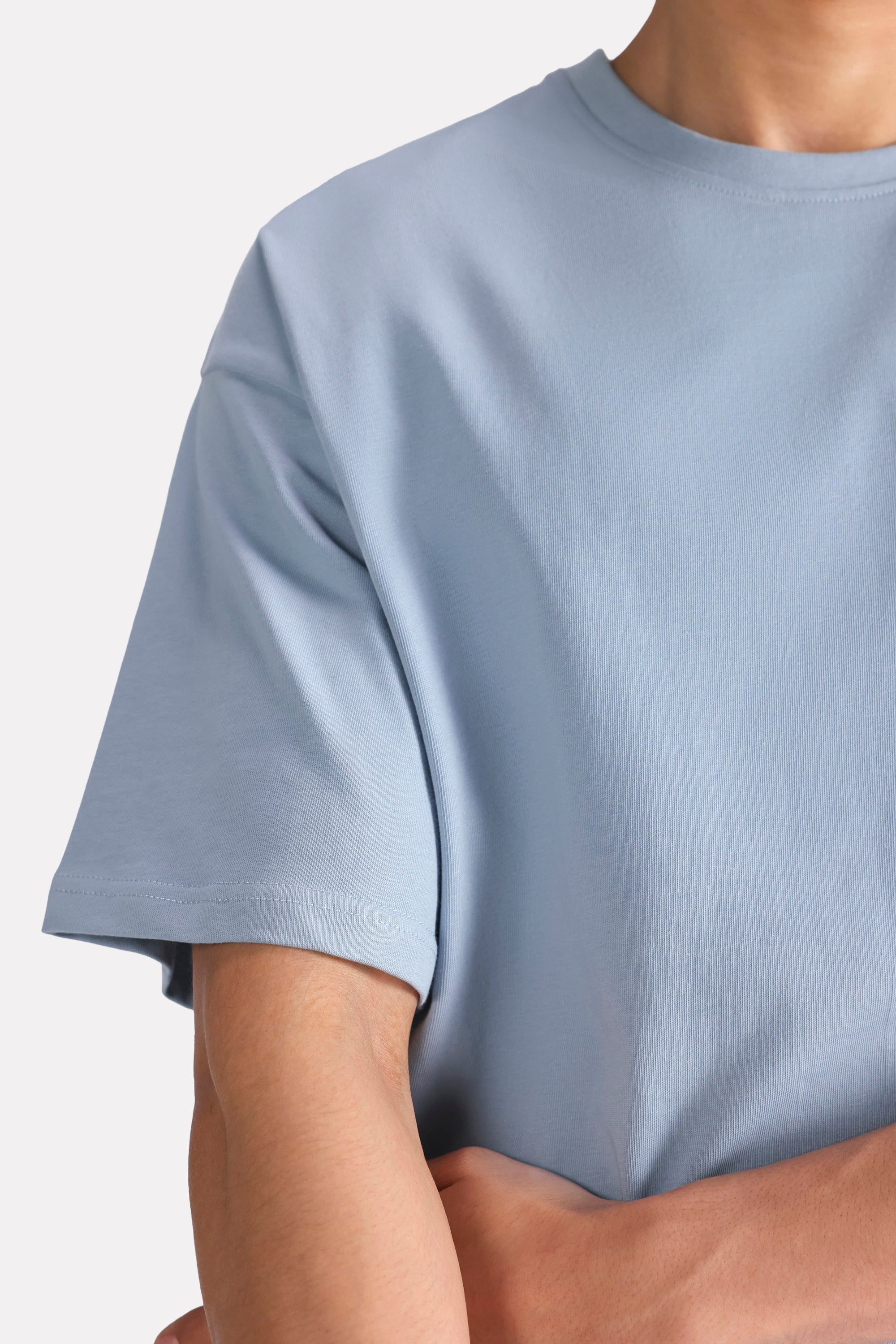 Faded blue (faded denim) drop shoulder cotton t-shirt shown in a styled fit, by SOLA Pakistan.