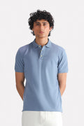 Faded blue (faded denim) micro-textured cotton pique polo, worn by a model, by SOLA Pakistan.