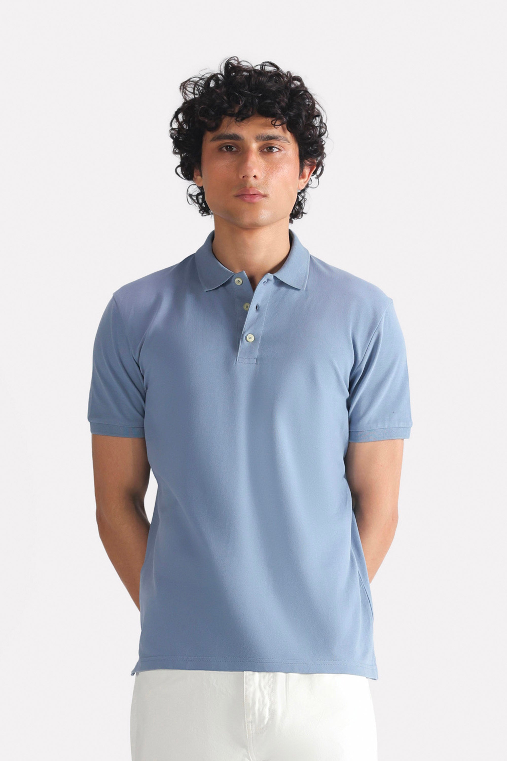 Faded blue (faded denim) micro-textured cotton pique polo, worn by a model, by SOLA Pakistan.