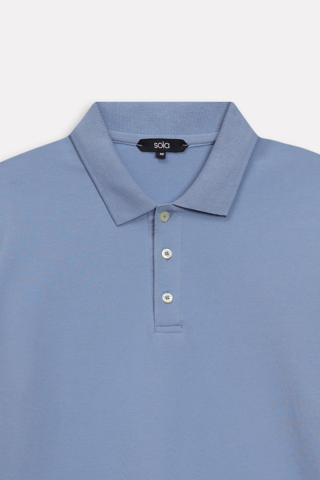 Texture and fabric detail, faded blue (faded denim) micro-textured cotton pique polo, by SOLA Pakistan.