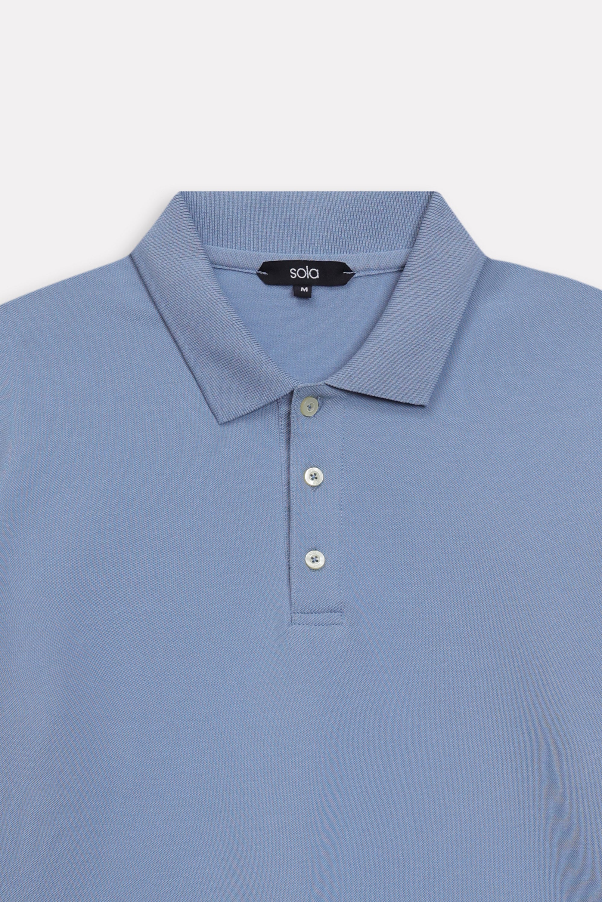 Texture and fabric detail, faded blue (faded denim) micro-textured cotton pique polo, by SOLA Pakistan.