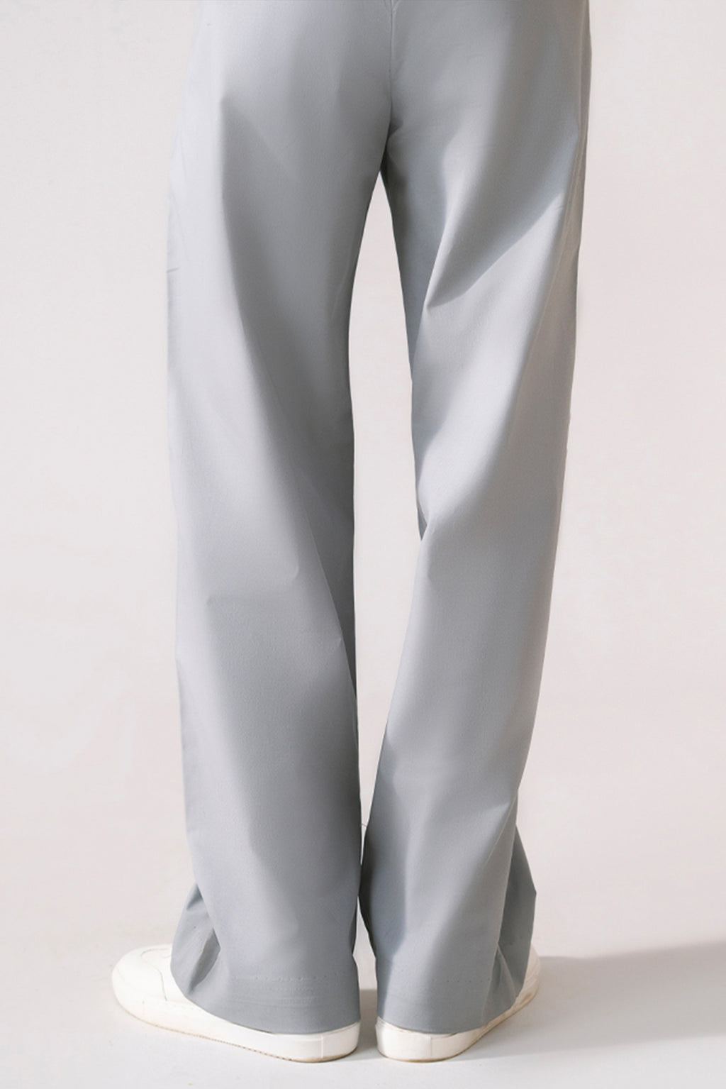 Close-up detail on the grey barrel-leg pleated trouser, by SOLA Pakistan.
