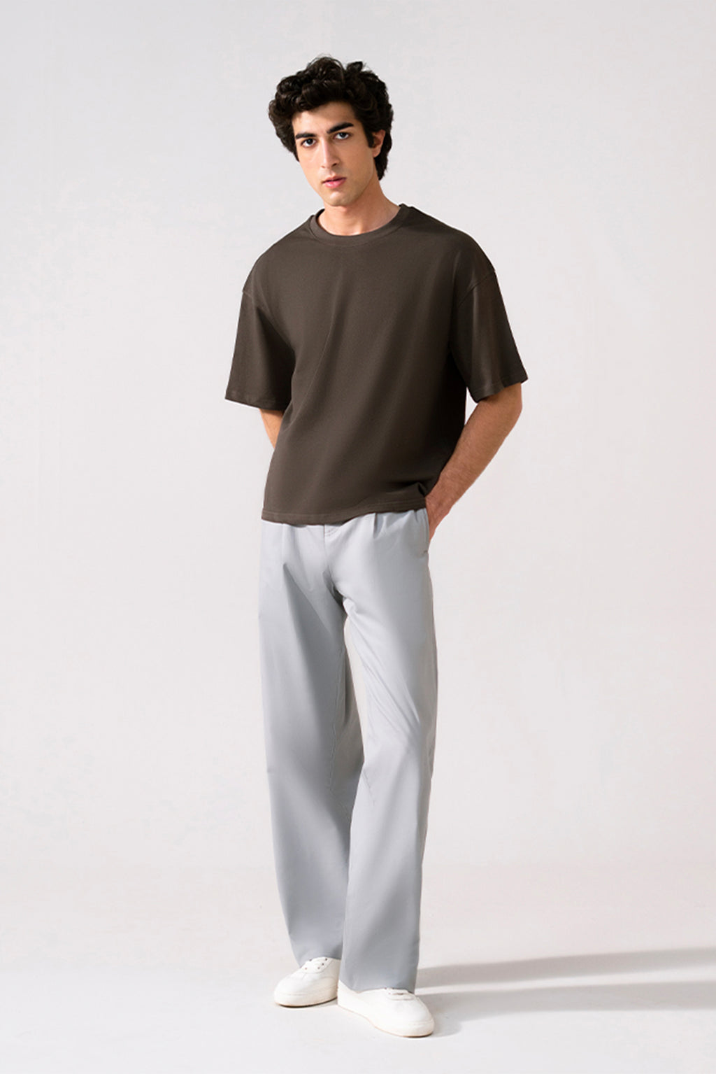 Grey barrel-leg pleated trouser in cotton, worn by a model, by SOLA Pakistan.