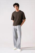 Grey barrel-leg pleated trouser in cotton, worn by a model, by SOLA Pakistan.