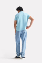 Flat lay of the light blue micro-textured cotton pique polo, by SOLA Pakistan.