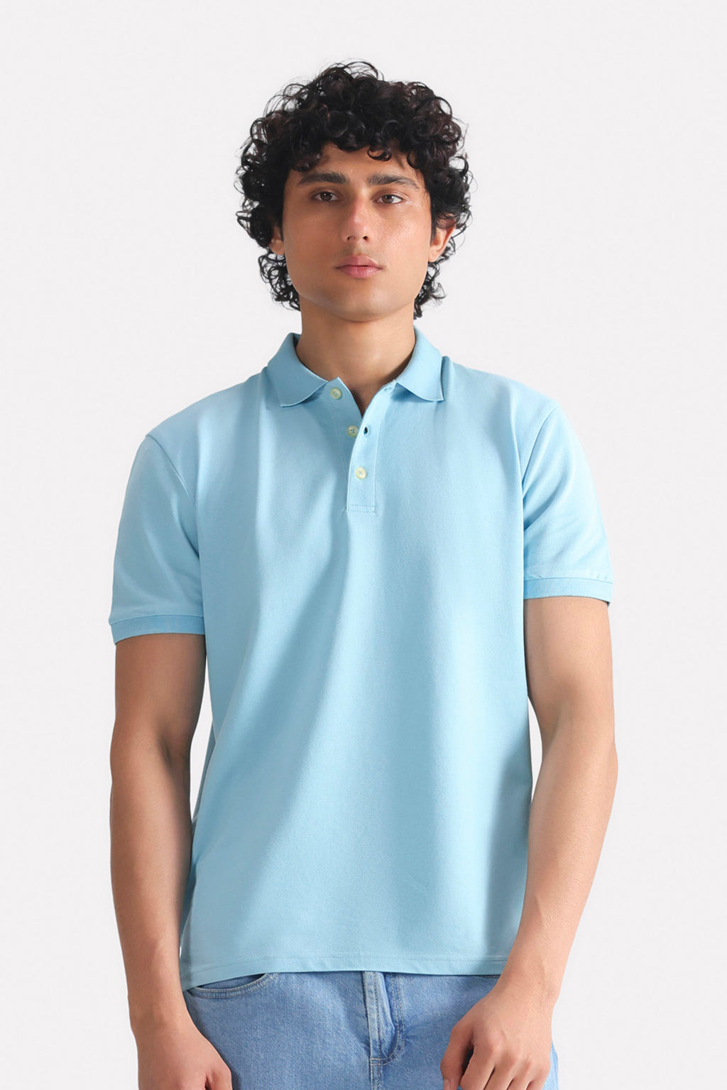 Light blue micro-textured cotton pique polo, worn by a model, by SOLA Pakistan.