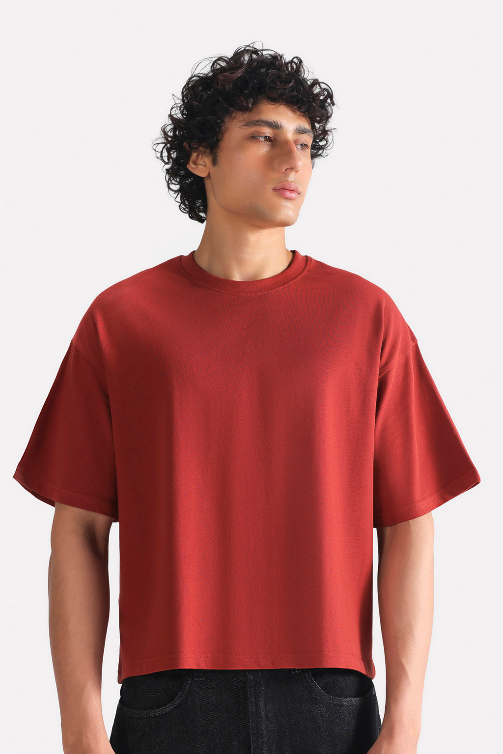 Matt red drop shoulder cotton t-shirt, worn by a model, by SOLA Pakistan.