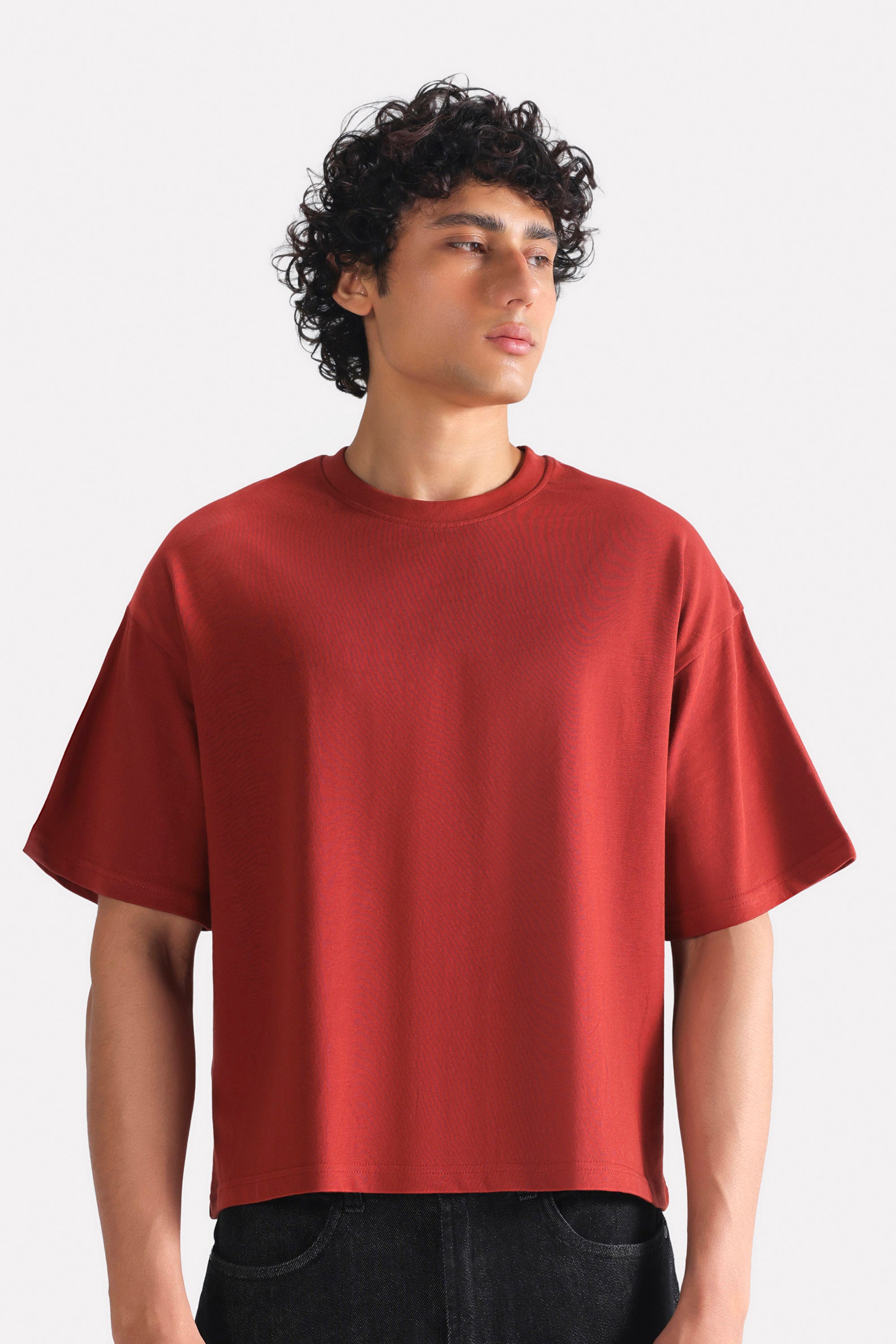 Matt red drop shoulder cotton t-shirt, worn by a model, by SOLA Pakistan.