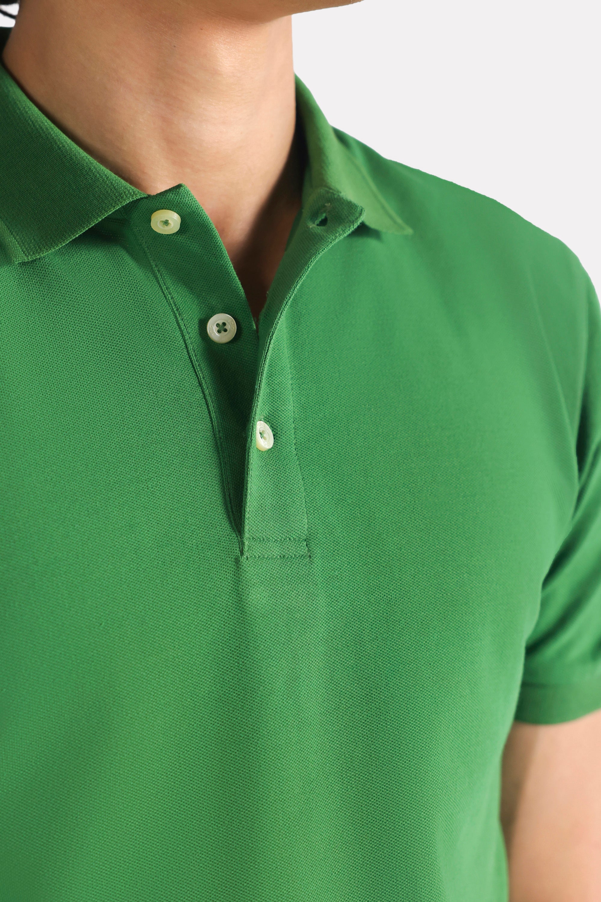 Close-up detail on the moss green micro-textured cotton pique polo, by SOLA Pakistan.