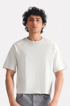 Off-white (cloud dancer) drop shoulder cotton t-shirt, worn by a model, by SOLA Pakistan.