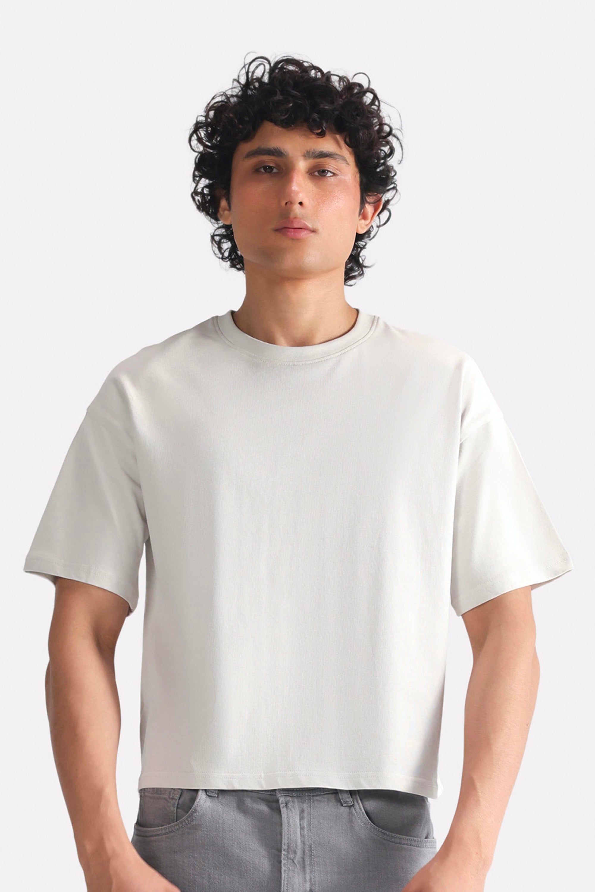 Off-white (cloud dancer) drop shoulder cotton t-shirt, worn by a model, by SOLA Pakistan.