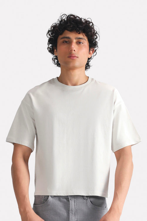 Off-white (cloud dancer) drop shoulder cotton t-shirt, worn by a model, by SOLA Pakistan.