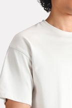 Off-white (cloud dancer) drop shoulder cotton t-shirt shown in a styled fit, by SOLA Pakistan.
