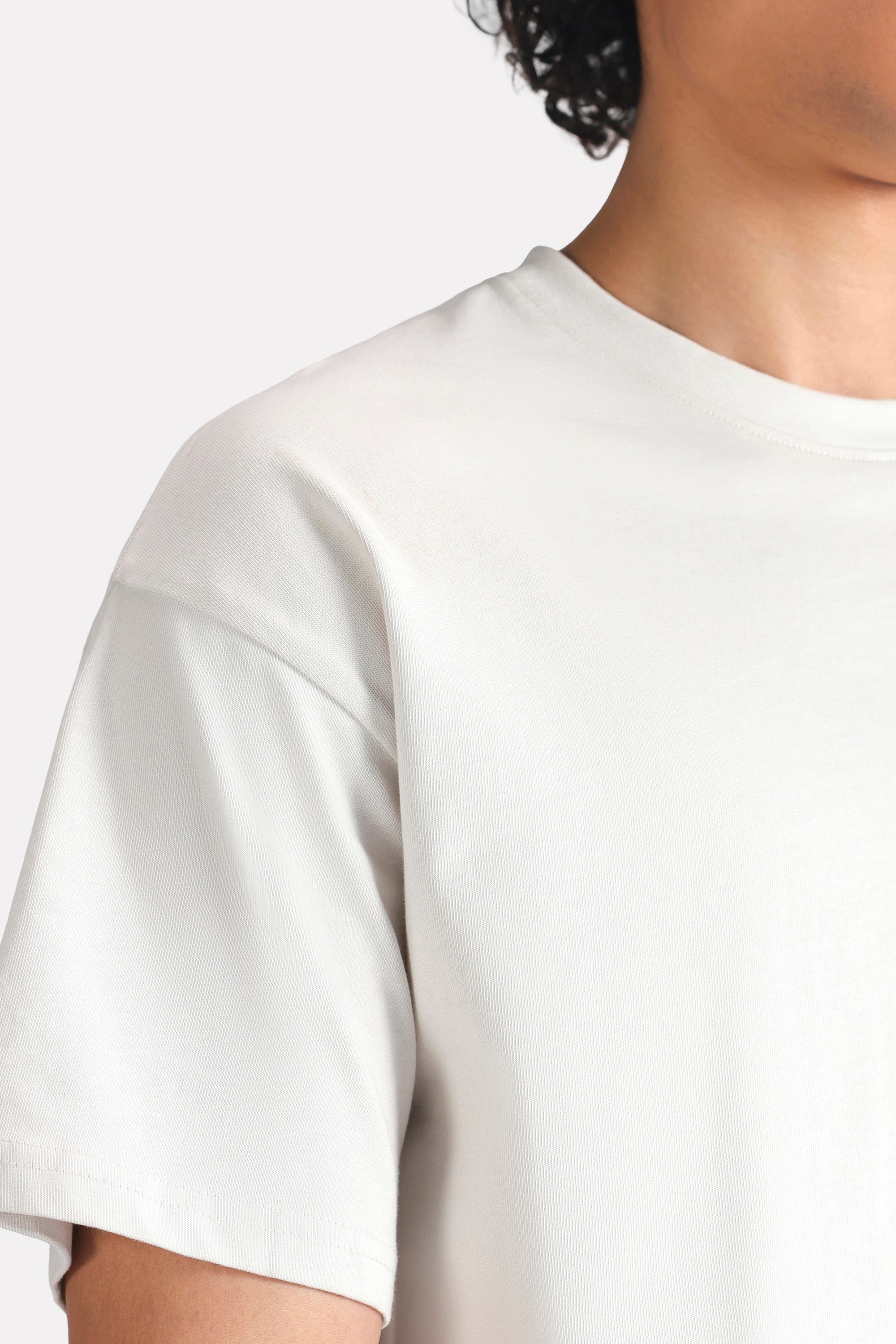 Off-white (cloud dancer) drop shoulder cotton t-shirt shown in a styled fit, by SOLA Pakistan.