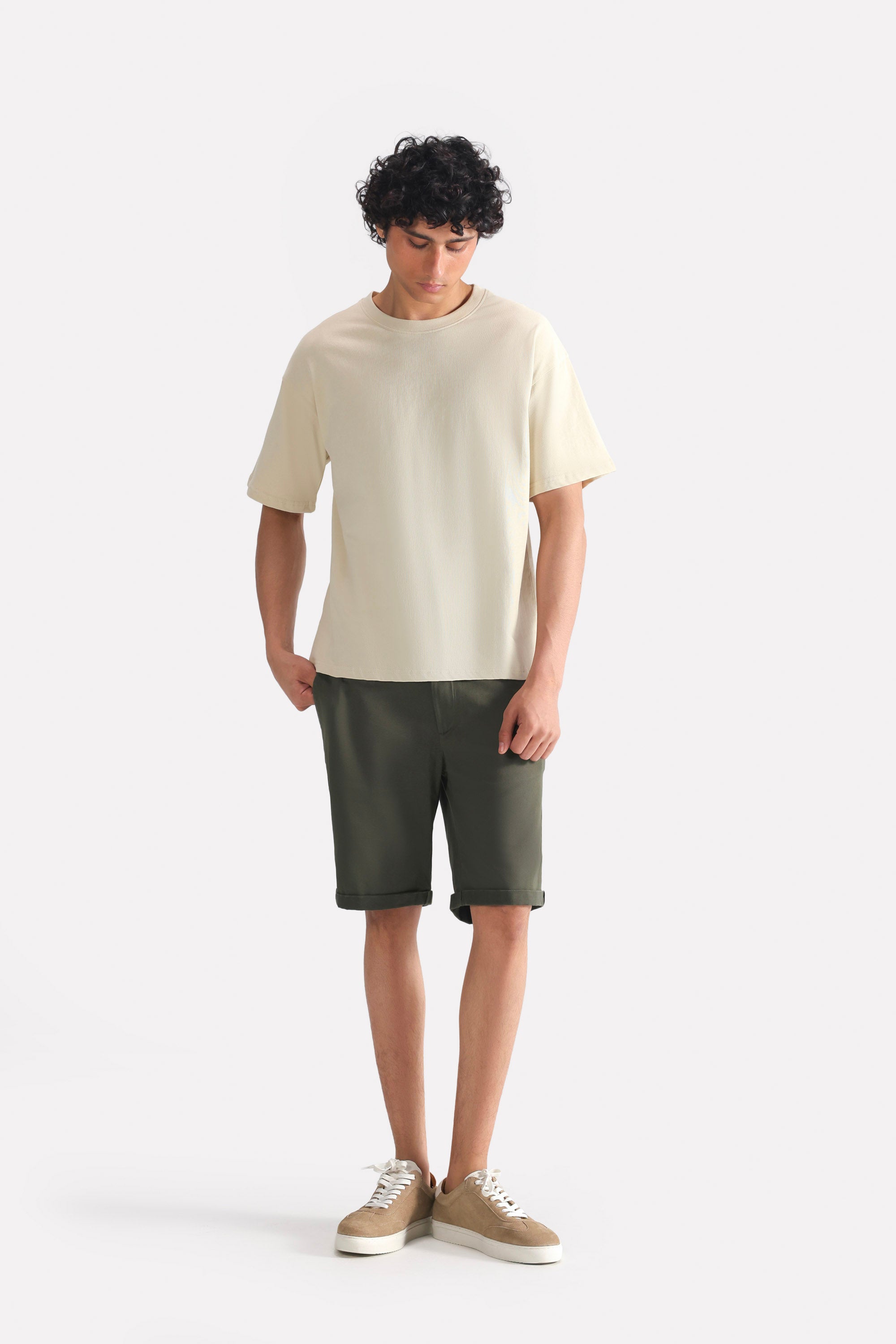 Olive relaxed fit cotton shorts, worn by a model, by SOLA Pakistan.