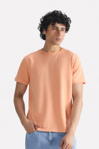 Peach (apricot) regular fit crew neck t-shirt in cotton, worn by a model, by SOLA Pakistan.