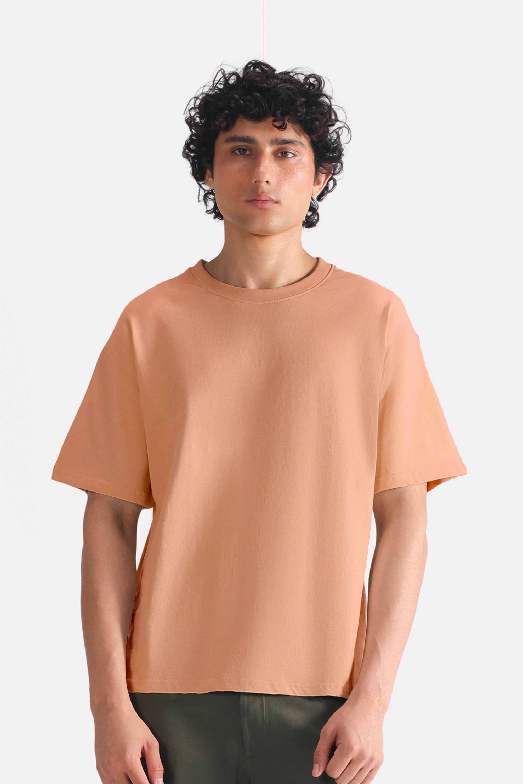 Terracotta (clay) drop shoulder cotton t-shirt, worn by a model, by SOLA Pakistan.