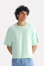 Turquoise (tourquies) drop shoulder cotton t-shirt, worn by a model, by SOLA Pakistan.