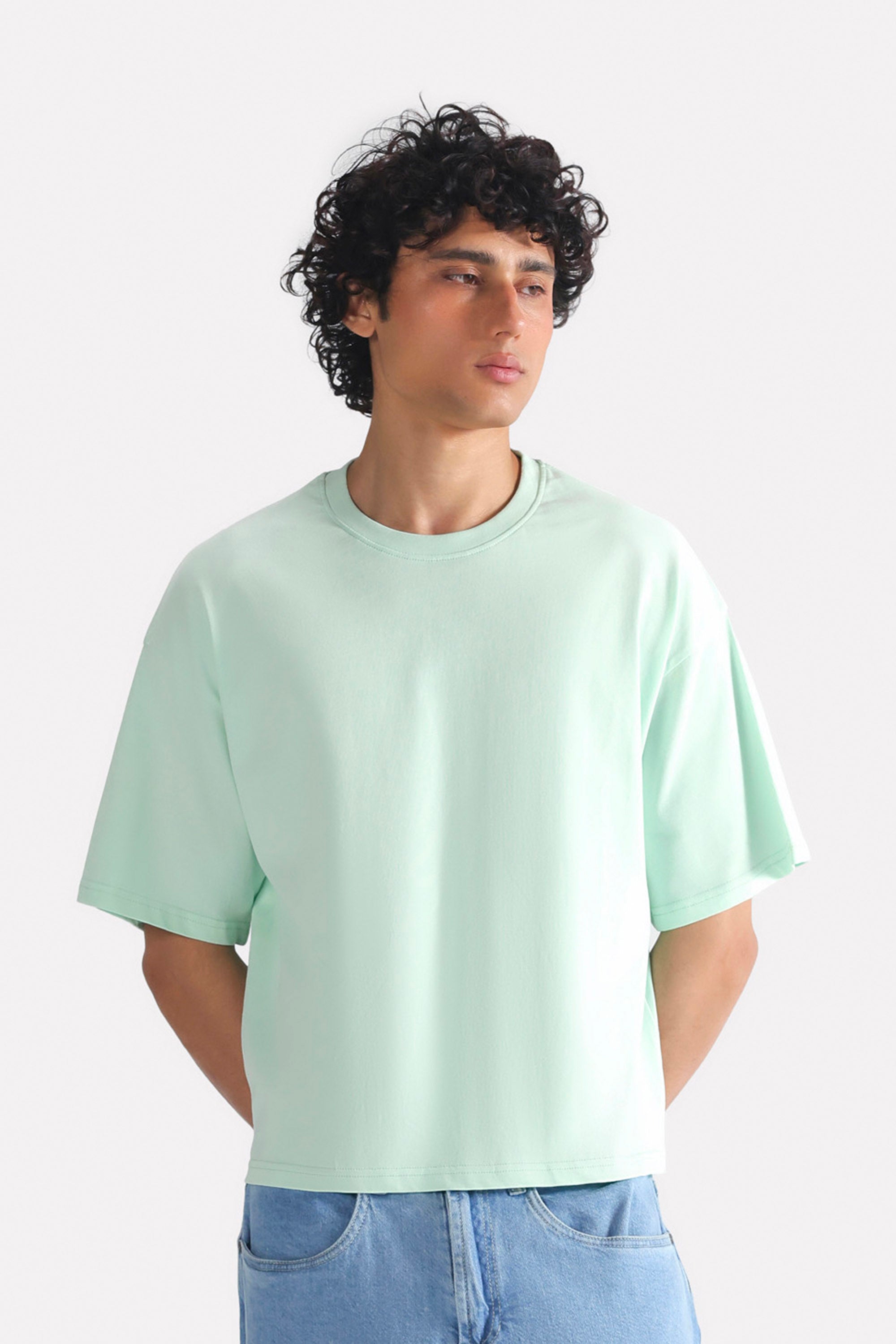 Turquoise (tourquies) drop shoulder cotton t-shirt, worn by a model, by SOLA Pakistan.
