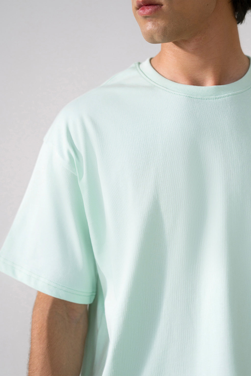 Close-up detail on the turquoise (tourquies) heavy weight cropped t-shirt, by SOLA Pakistan.