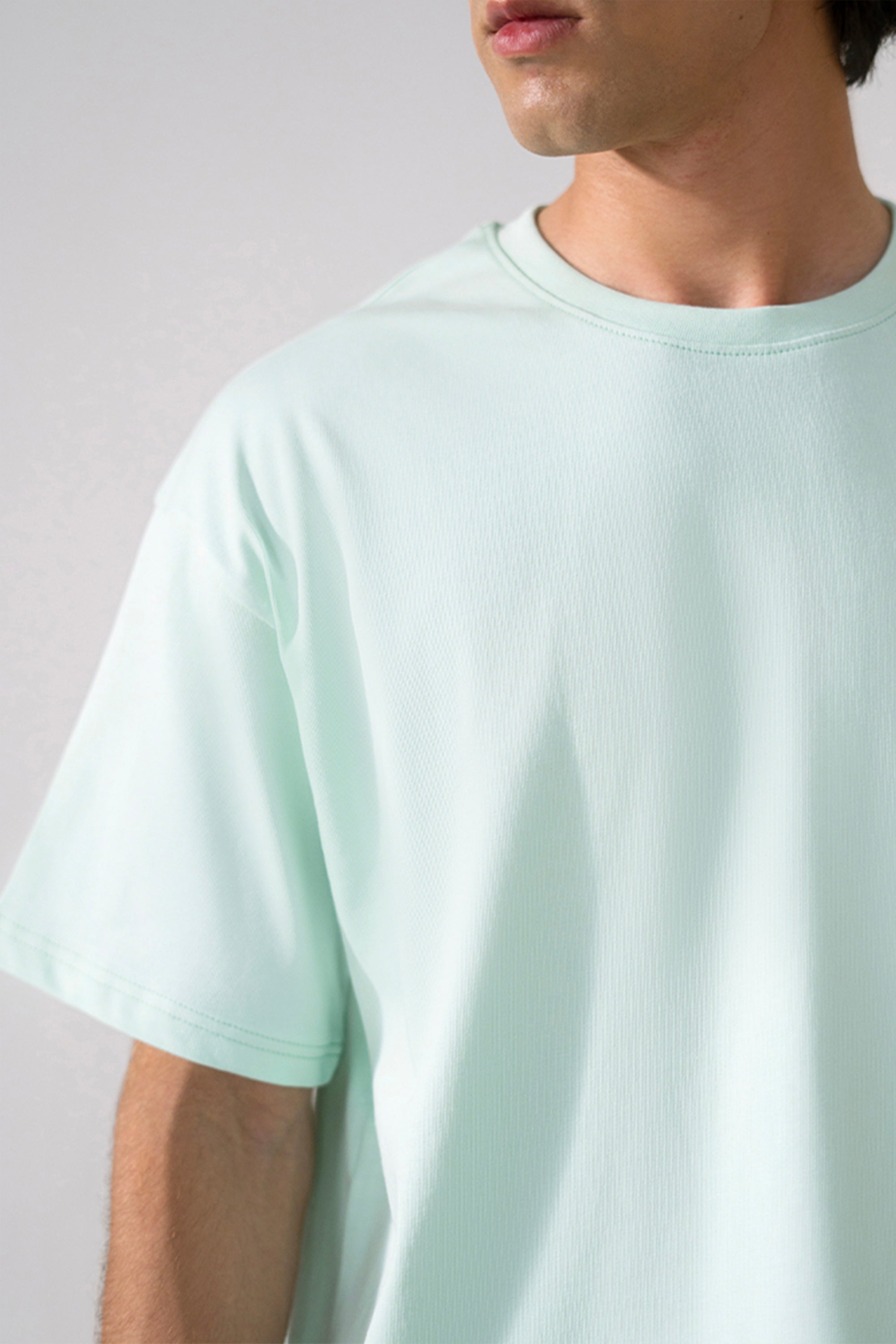 Close-up detail on the turquoise (tourquies) heavy weight cropped t-shirt, by SOLA Pakistan.