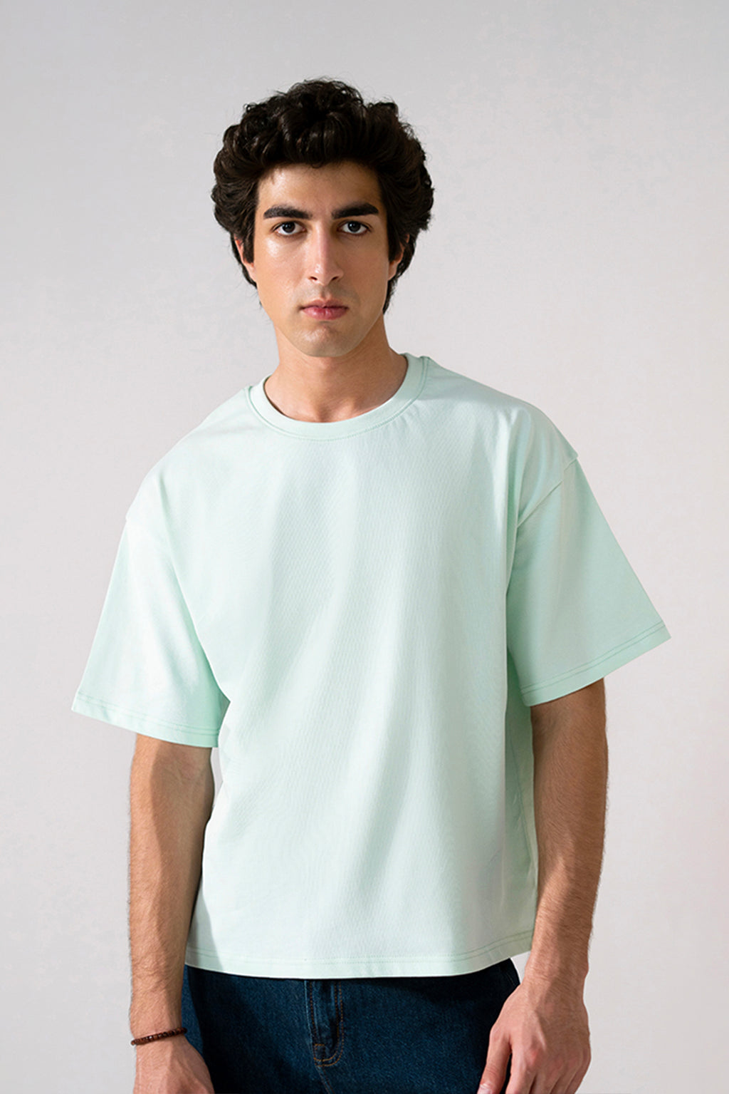Turquoise (tourquies) heavy weight cropped t-shirt in cotton, worn by a model, by SOLA Pakistan.