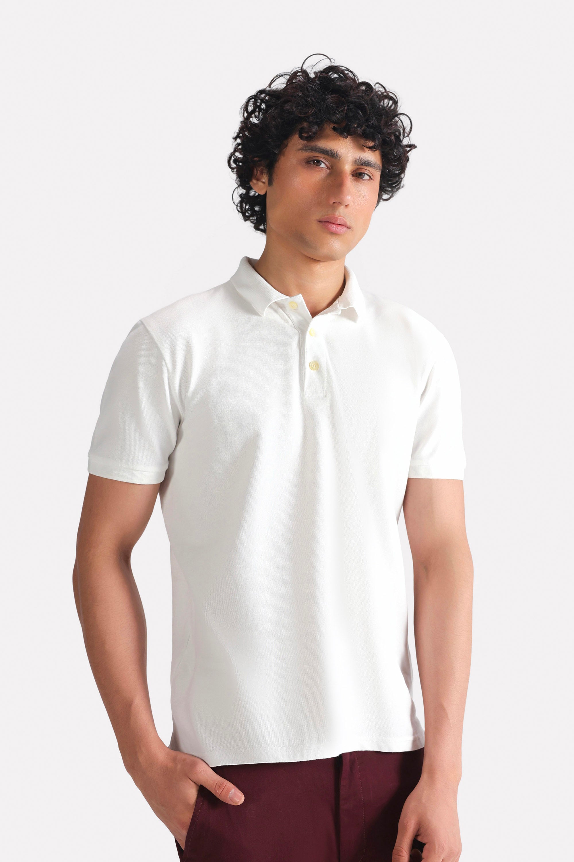 White micro-textured cotton pique polo, worn by a model, by SOLA Pakistan.