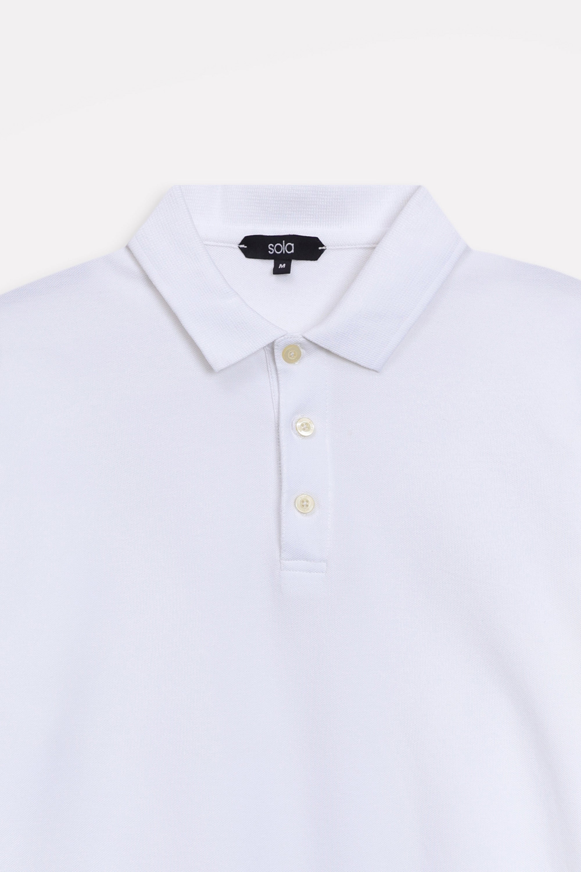 Texture and fabric detail, white micro-textured cotton pique polo, by SOLA Pakistan.