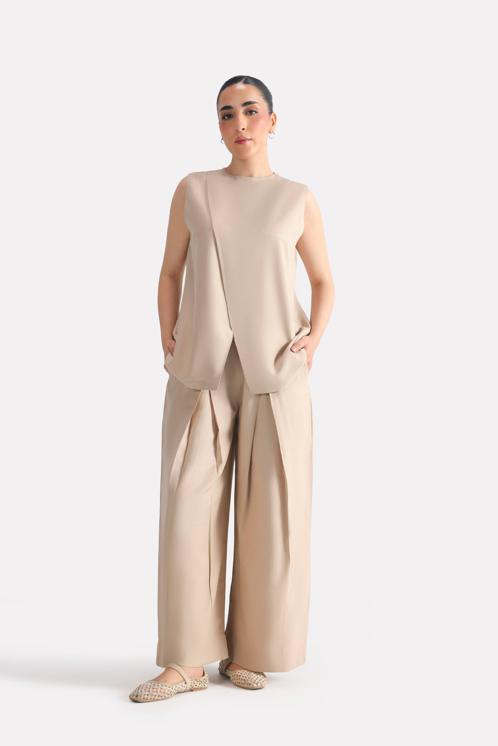 Beige pleated co-ord bottom in polyester-silk blend, worn by a model, by SOLA Pakistan.