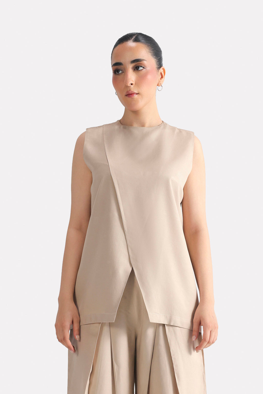 Beige pleated co-ord top in polyester-silk blend, worn by a model, by SOLA Pakistan.