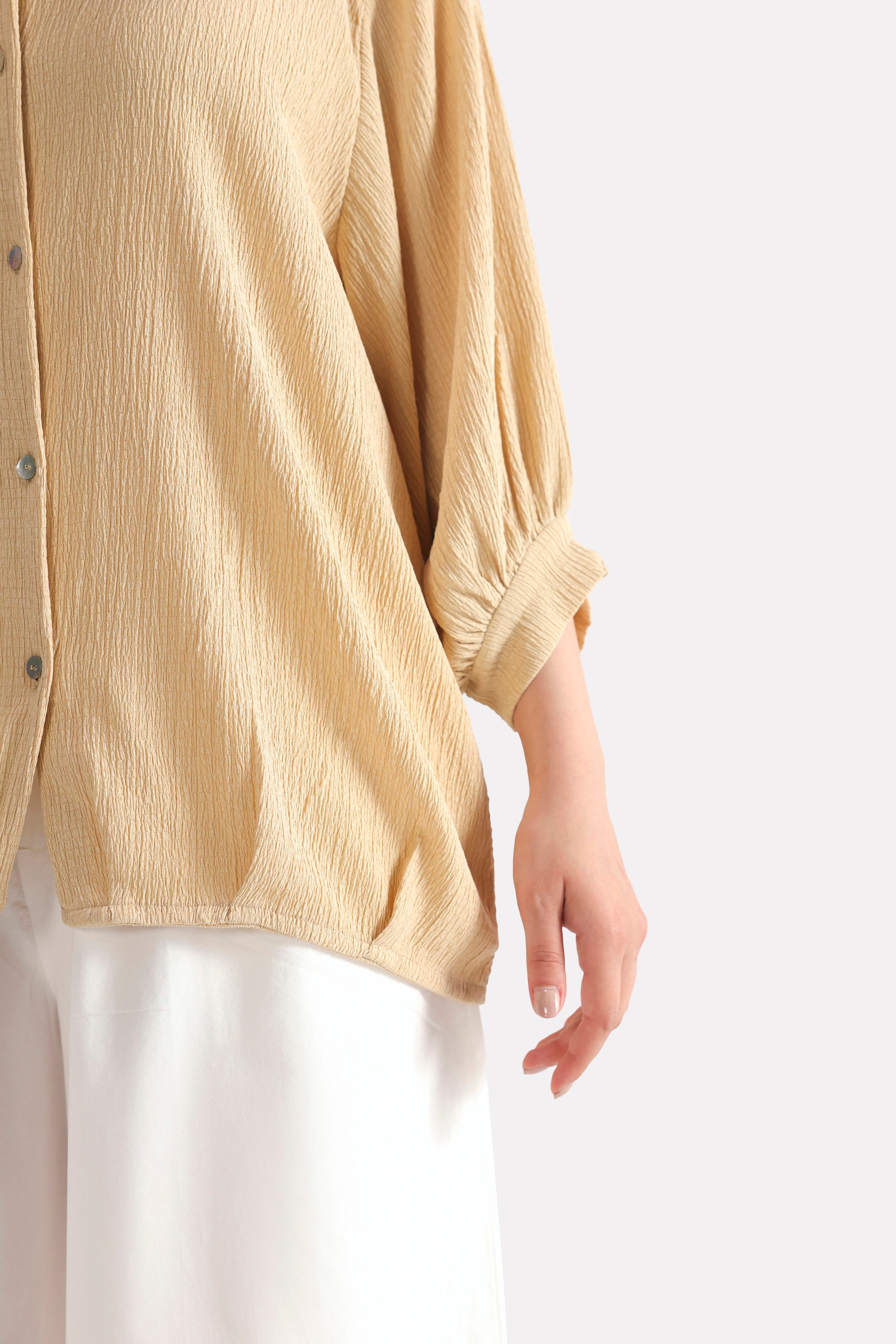 Texture and fabric detail, beige pleated hem woven top, by SOLA Pakistan.